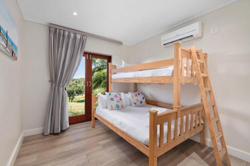 1 dormitorio con 2 literas y ventana en San Lameer Villa 14110 - 5 Bedroom Luxury - 10 pax - San Lameer Rental Agency en Southbroom