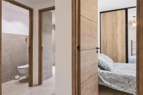 um quarto com uma porta de correr com uma cama e uma casa de banho em Casa U Castagnettu 2 em Patrimonio