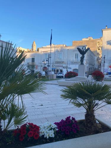 een binnenplaats met bloemen en een standbeeld en gebouwen bij Monolocale Elena in Vieste