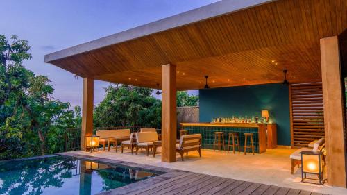 eine Terrasse mit einer Bar neben einem Pool in der Unterkunft Sanglung Villas & Suites in Kubutambahan