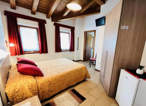 una camera da letto con un letto con cuscini rossi di Agriturismo Luis Gianni a Cividale del Friuli