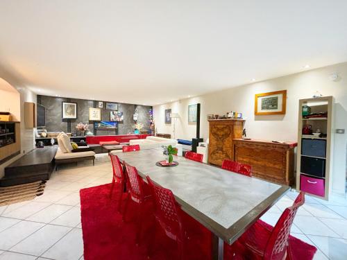 - un salon avec une grande table et des chaises rouges dans l'établissement Grand appartement avec jardin privatif à Paris, à Paris