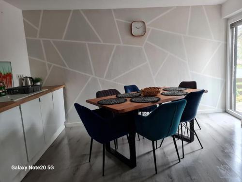 a dining room table with chairs and a clock on the wall at Lilias Ruheoase in Pfungstadt