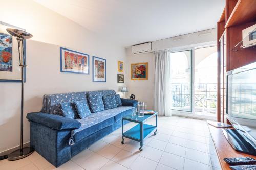 un salon avec un canapé bleu et une table dans l'établissement Queen Garden - Happy Rentals, à Menton
