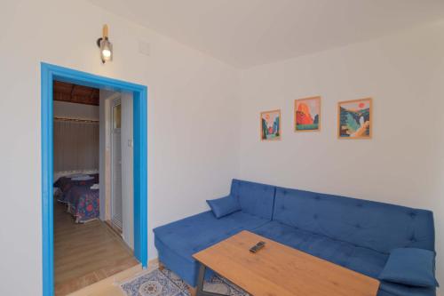 a living room with a blue couch and a wooden table at Adrasan Hotel in Kumluca