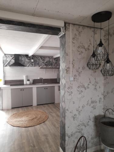 Habitación con cocina con mesa y algunas luces. en Smith Cosy en Châteaumeillant