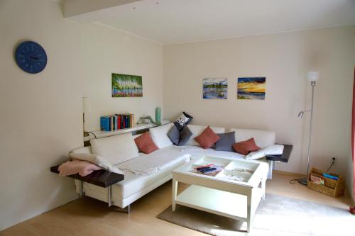 uma sala de estar com um sofá branco e uma mesa em Gemütliches Haus mit großem traumhaften Garten em Bremen