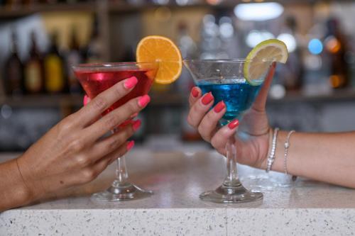 two people holding martini glasses on a counter at San Lameer Villa 14201 - 5 Bedroom Superior - 10 pax - San Lameer Rental Agency in Southbroom