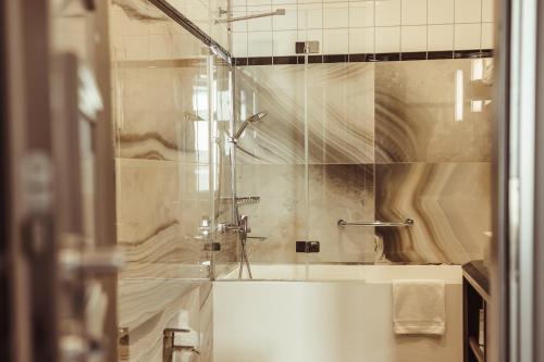 a bathroom with a shower with a glass door at Grand Poet Hotel and SPA by Semarah in Riga