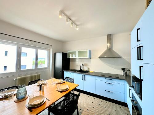 Il comprend une cuisine avec une table en bois et des placards bleus. dans l'établissement Bel appartement 100 m2 / Parking / Paisible, à Rodez