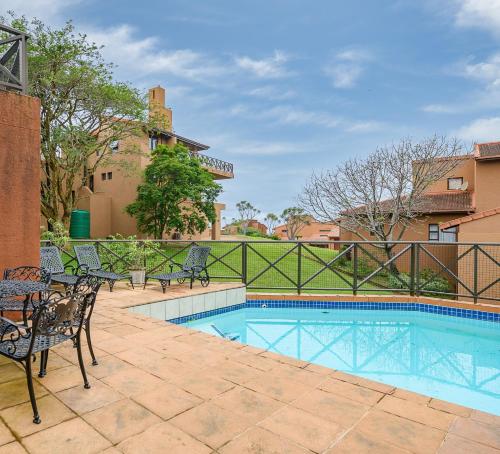 a resort style swimming pool with chairs and a fence at San Lameer Villa 14201 - 5 Bedroom Superior - 10 pax - San Lameer Rental Agency in Southbroom