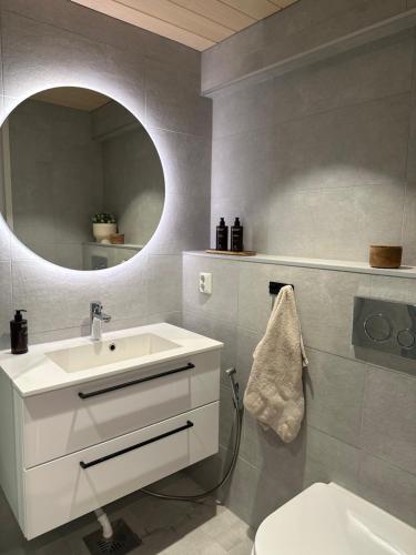 a bathroom with a white sink and a mirror at Arctic City Apartment in Rovaniemi