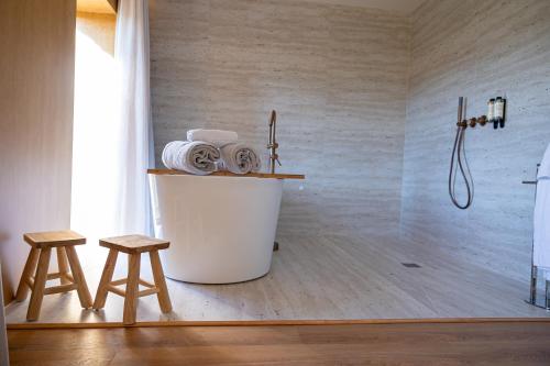 a bathroom with a tub and two stools at Peso Village in Amarante