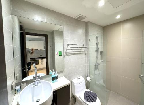 een badkamer met een wastafel, een toilet en een spiegel bij Private apartment at Emerald Terrace in Patong Beach