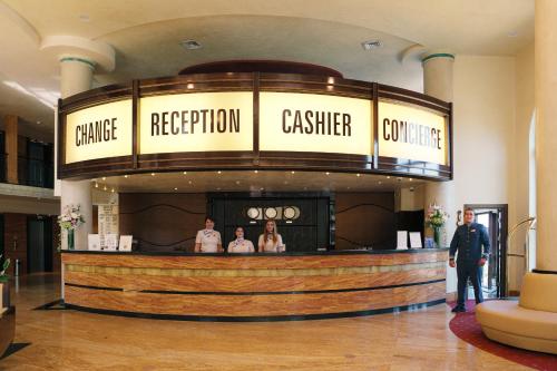 a group of people standing at a bar in a lobby at Admiral Hotel - Ultra All Inclusive & Private Beach in Golden Sands