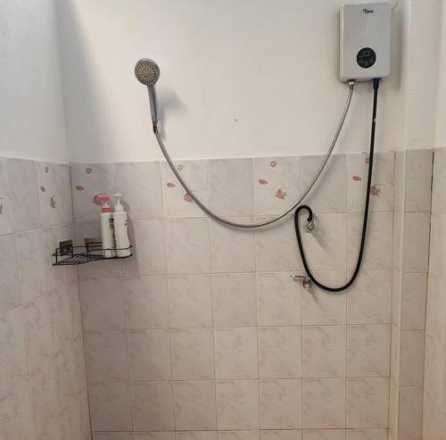 um chuveiro na casa de banho com uma mangueira na parede em บ้านพักในสวนK&N1 