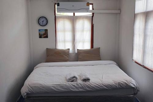 uma cama num quarto com um relógio na parede em บ้านพักในสวนK&N1 