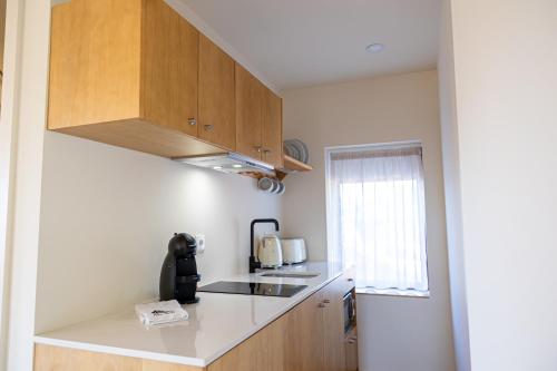 a small kitchen with wooden cabinets and a sink at Peso Village in Amarante