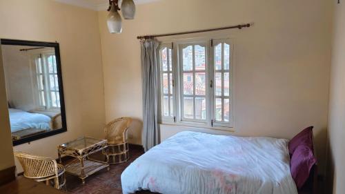 a bedroom with a bed and a mirror and a window at Bodhi Homestay in Kathmandu