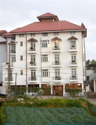 um grande edifício branco com um telhado vermelho em Royal Pearl Hills em Nuwara Eliya