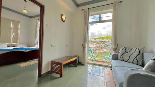 uma sala de estar com um sofá, uma cama e uma janela em Royal Pearl Hills em Nuwara Eliya