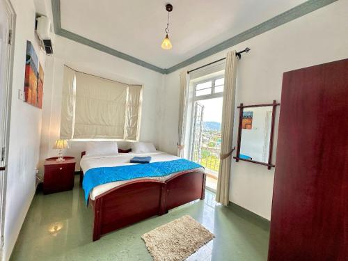 um quarto com uma cama e uma grande janela em Royal Pearl Hills em Nuwara Eliya