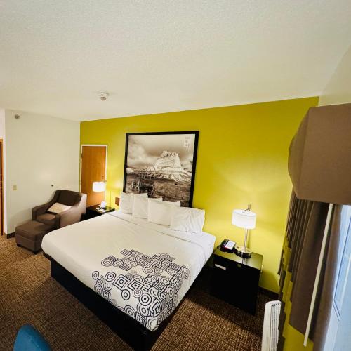 a hotel room with a bed and a chair at Forest City Inn in Forest City