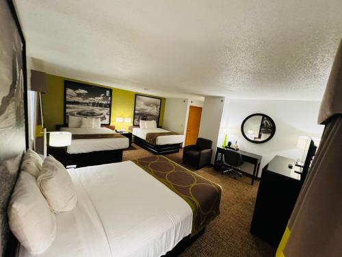 a large hotel room with two beds and a desk at Forest City Inn in Forest City