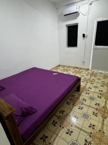 sypialnia z fioletowym łóżkiem w pokoju w obiekcie Madina Palace Inn w Kolombo