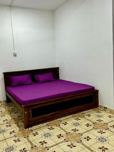 łóżko z fioletową pościelą w pokoju w obiekcie Madina Palace Inn w Kolombo