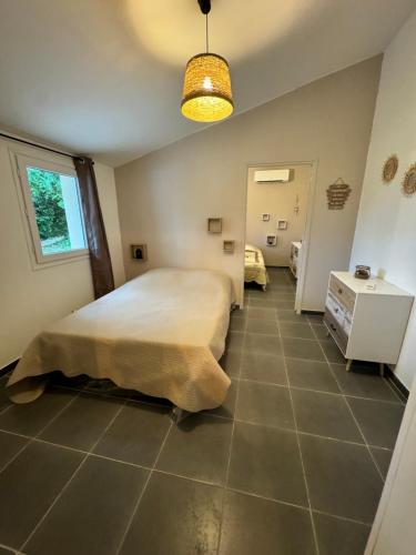 ein Schlafzimmer mit einem Bett und Fliesenboden in der Unterkunft MAZET en CAMPAGNE in Arles