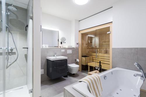 ein Badezimmer mit einer Badewanne, einem Waschbecken und einem WC in der Unterkunft Peters Lodge 1 in Grömitz
