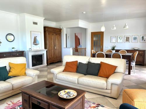 a living room with two couches and a table at CASA PANORAMICA VUE MER 8 a 10 Personnes in Boliqueime