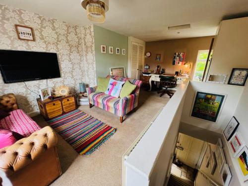 sala de estar con sofá y TV en The Little House en Bradford