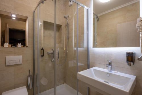 a bathroom with a glass shower and a sink at Nobel West Hotel in Belgrade