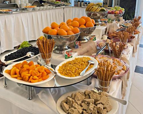 a buffet with many plates of food on a table at Arena Grand Hotel in Quba