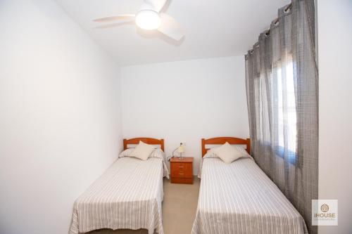 a bedroom with two beds and a window at Herminia in La Herradura