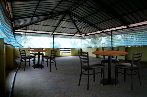 un grupo de mesas y sillas en una habitación en Kochu Mariya Residency en Punalūr