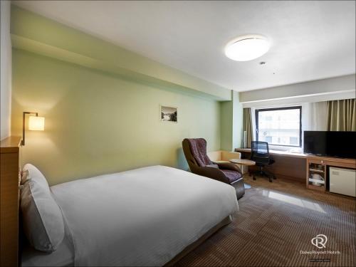 a hotel room with a bed and a chair and a television at Daiwa Roynet Hotel Okinawa-Kenchomae in Naha