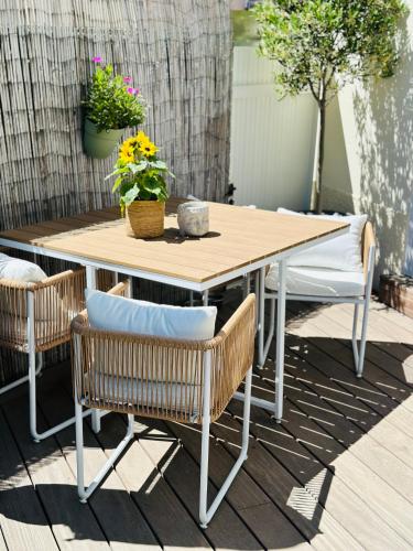 une table et des chaises en bois sur une terrasse dans l'établissement Séjour Détente! Jacuzzi + Jardin privés, à Saint-Raphaël