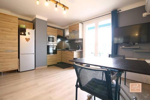 une cuisine avec une table et un réfrigérateur blanc dans l'établissement Le Criotto, à La Seyne-sur-Mer