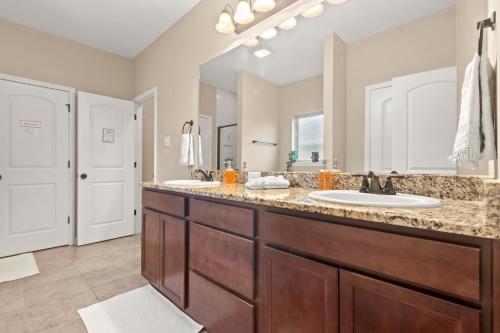 a bathroom with two sinks and a large mirror at Plush Bedshigh-speed Wi-fi Workspace in Lake Charles