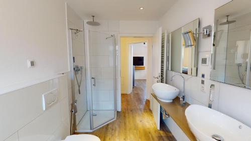 La salle de bains est pourvue de 2 lavabos et d'une douche en verre. dans l'établissement 54° Nord Wohnung 2, à Grömitz