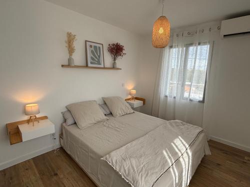 une chambre blanche avec un lit et une fenêtre dans l'établissement Villa Jade - Saint palais sur mer - entre mer et golf, à Saint-Palais-sur-Mer