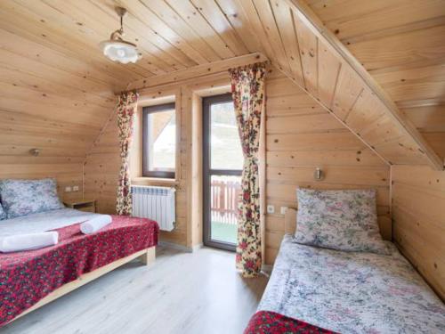 um quarto com 2 camas num chalé de madeira em Domek w Pieninach em Grywałd