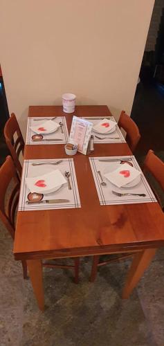 a wooden table with plates and utensils on it at Agriturismo Cà Del Lago in Gravedona