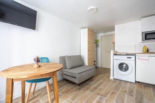 une cuisine et une salle à manger avec une table et un lave-linge dans l'établissement 1d Studio Central Paris Sébastopol République, à Paris