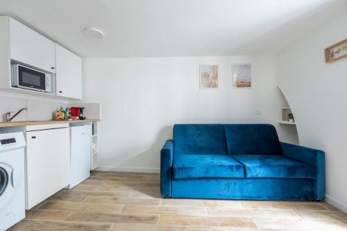 - un canapé bleu dans le salon avec un four micro-ondes dans l'établissement 1d Studio Central Paris Sébastopol République, à Paris