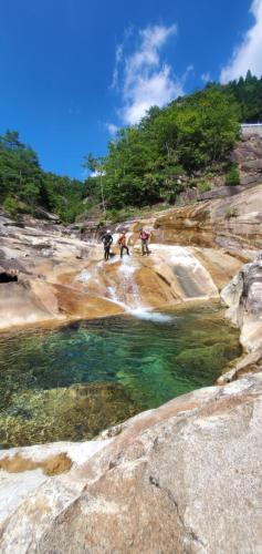 a group of people on a rocky hill with a body of water at まちなかlodge ほしとたきび 一組様限定のお宿 レビューAward受賞 in Ōmuta