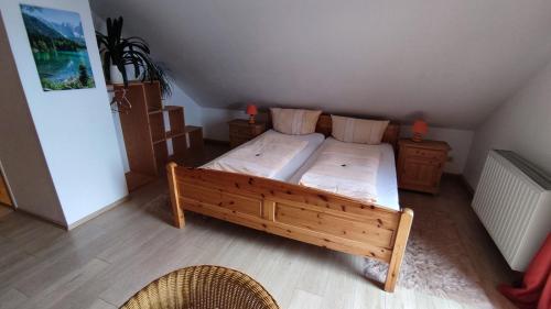 a bedroom with a wooden bed and two chairs at Berggasthaus & Pension Schöne Aussicht in Klingenthal